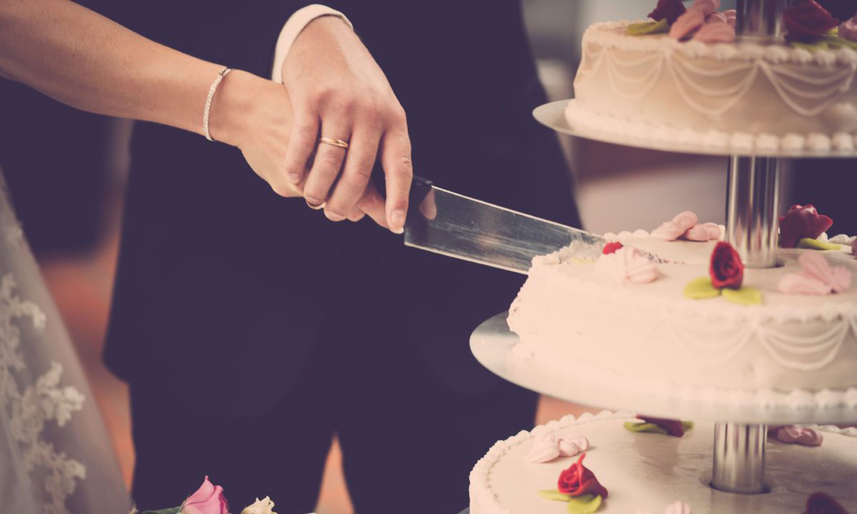 husband wife cutting cake