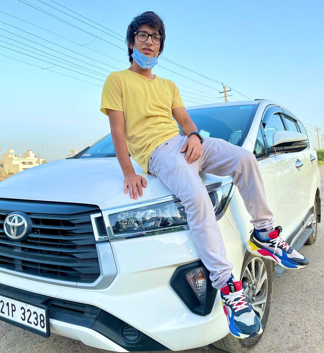 Sourav Joshi sitting on car bonnet